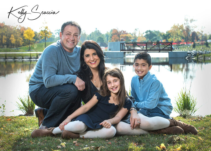 family of four outdoor fall portrait, all wearing blue clothing, smiling and looking at you, hugging