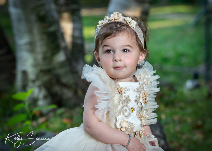 Outdoor baby girl portrait in the park wearing cream 