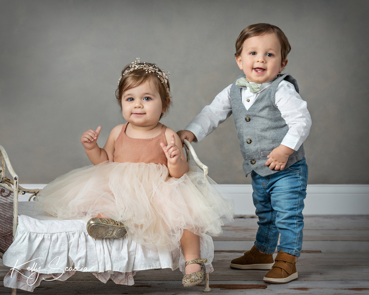 Studio portrait, fraternal twin girl and boy, looking at you smiling