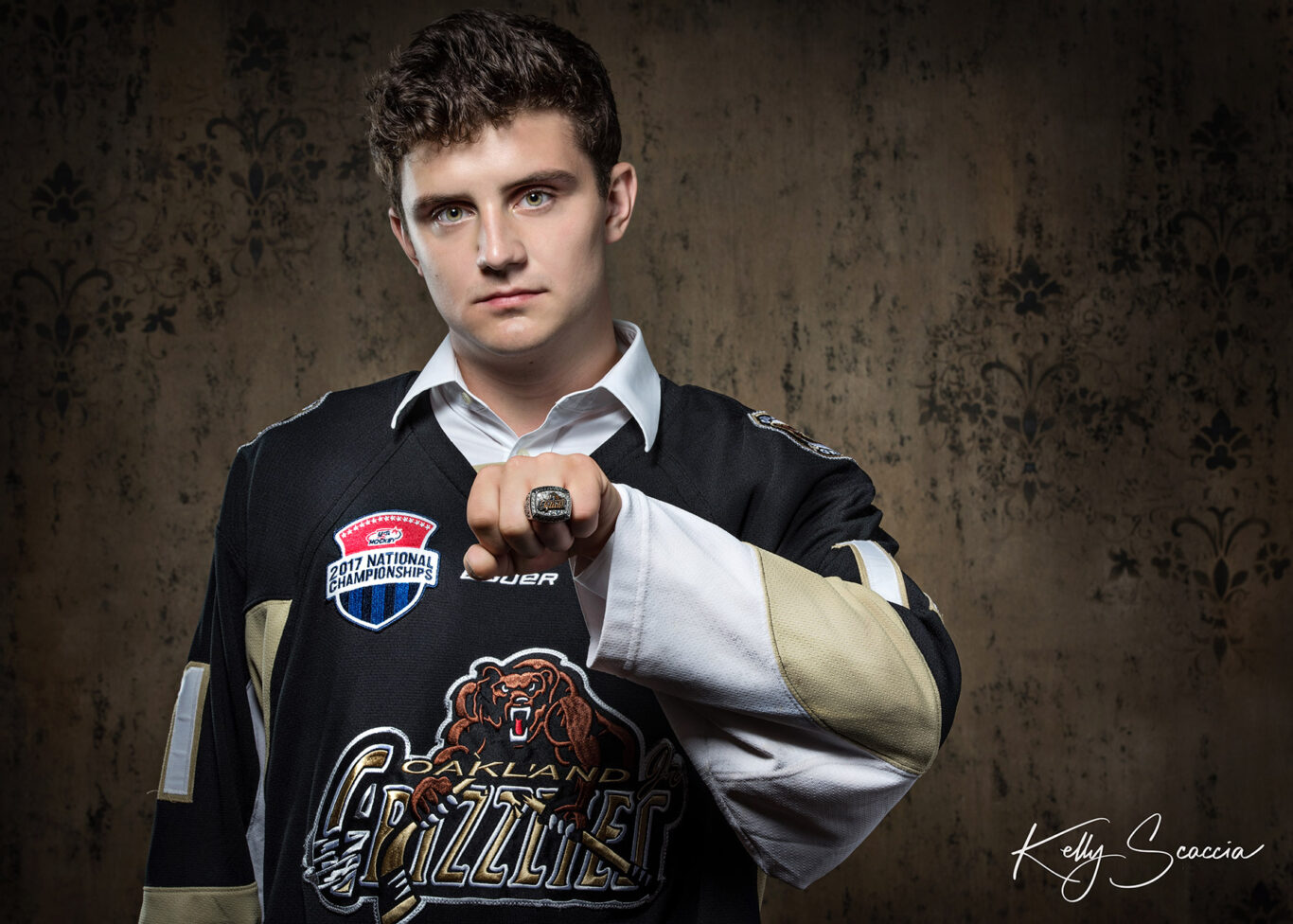 High School senior guy studio portrait wearing hockey jersey and season ring