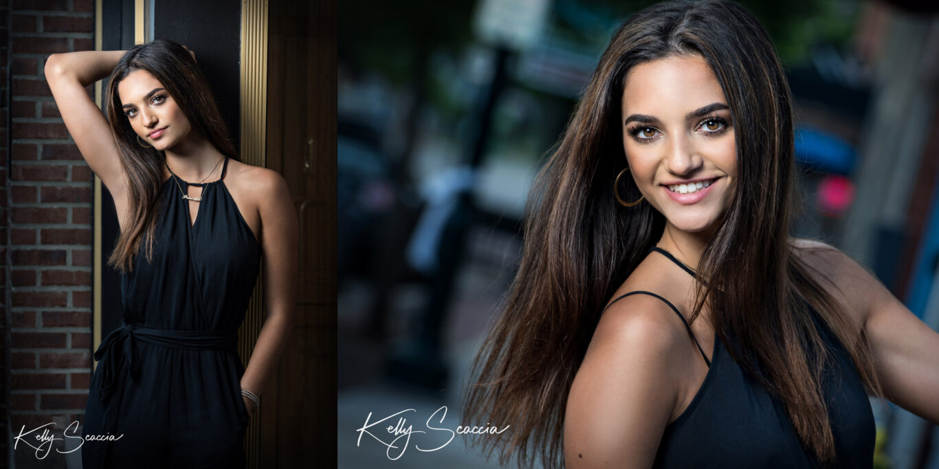 Outdoor senior portrait of a girl with long, dark hair wearing a black pantsuit smiling and looking directly at you in a city